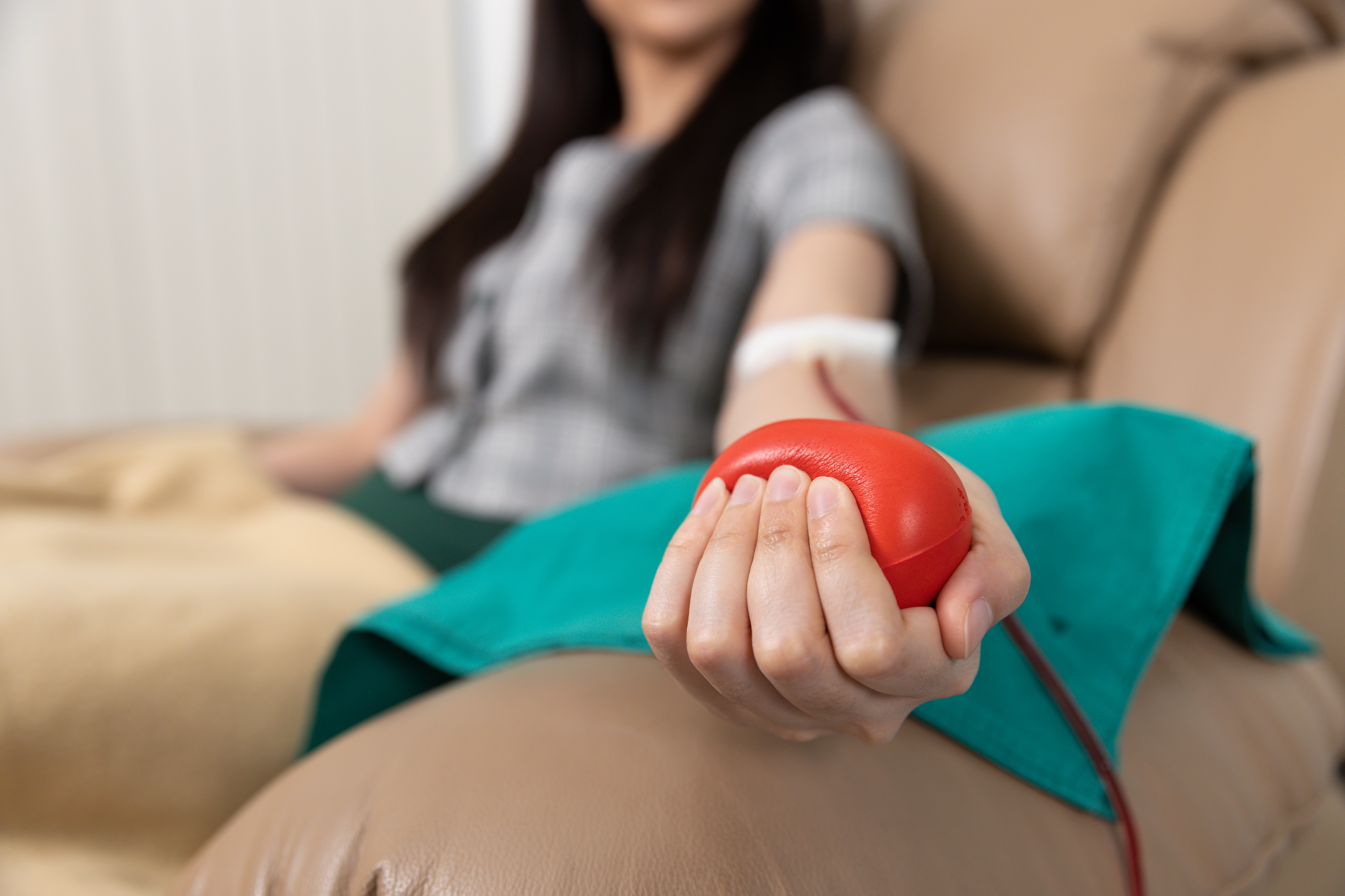Person squeezes stress ball while giving blood